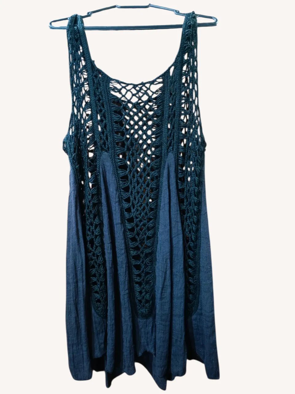 Vestido de playa sin mangas con detalles de crochet en la parte superior y falda de tela con pliegues.