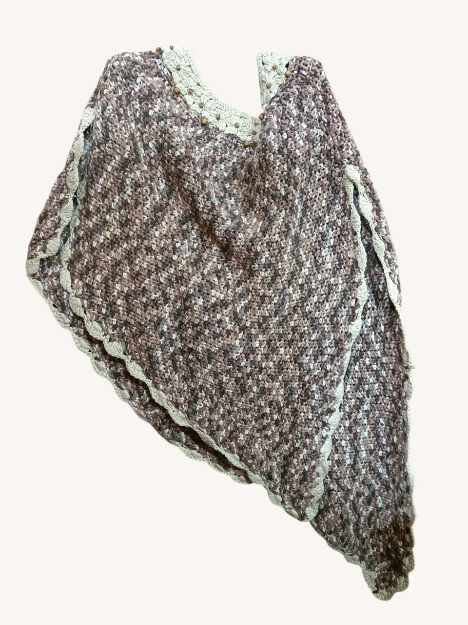 Poncho tejido en crochet, con un diseño de flores y detalles de cuentas de madera en el cuello. Ideal para un look boho chic o casual.