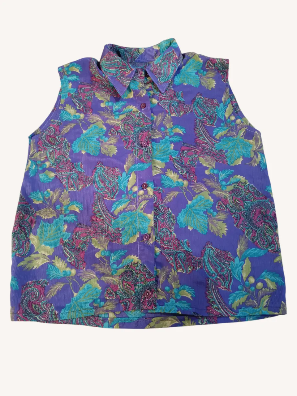 Camisa con cuello camisero y botones al frente. Estampado floral y de estilo paisley en tonos violeta, verde y fucsia.