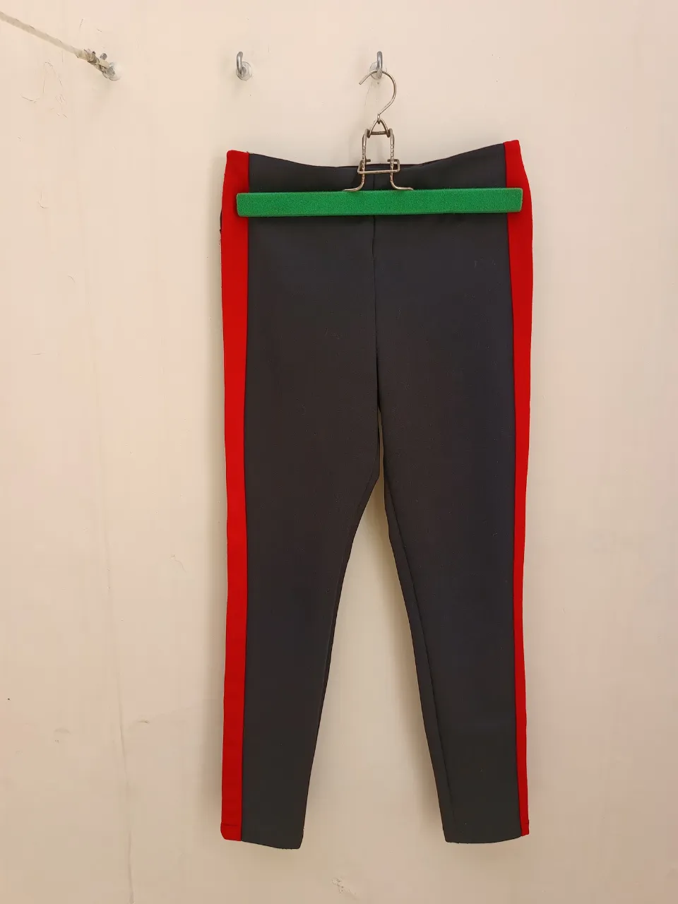 Pantalón tipo calza negra con franja lateral roja. Ideal  para un look casual y comodo