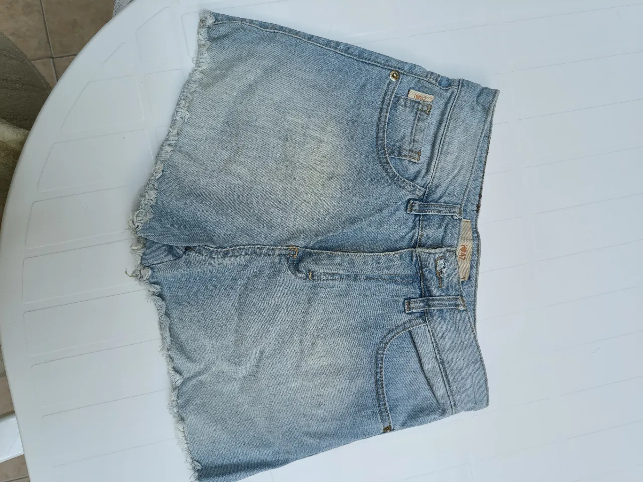 Shorts de jean tiro alto con estampa de tigre en el bolsillo trasero. Un diseño único y canchero para destacar tu estilo.