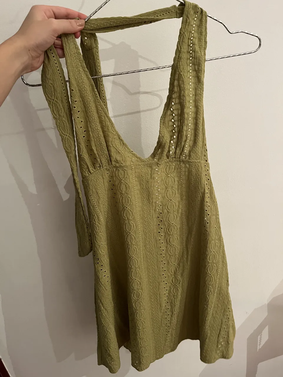 Vestido tejido verde con escote halter y detalles calados. Ideal para un look playero o casual de verano.
