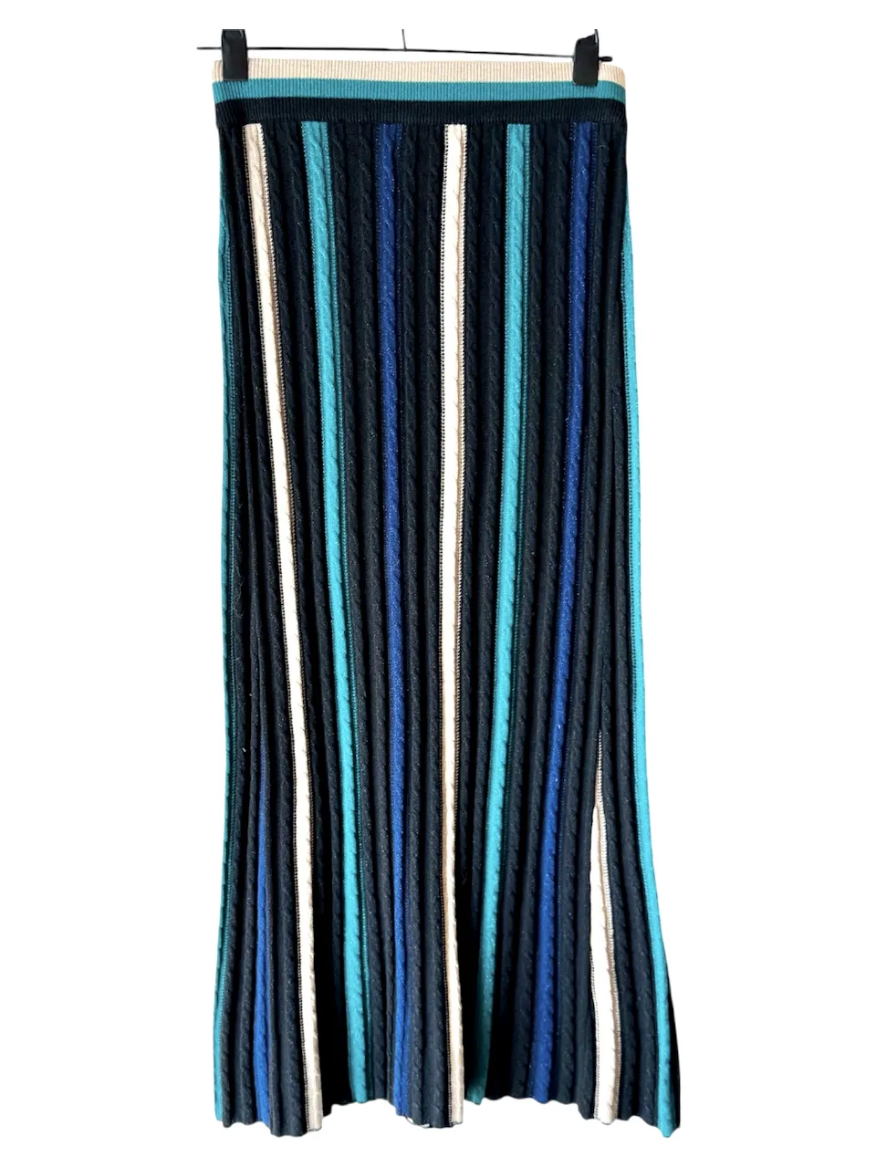 Pollera larga de punto con diseño de rayas verticales en varios colores. Tiene una abertura lateral y cintura elastizada. Ideal para un look casual y moderno.