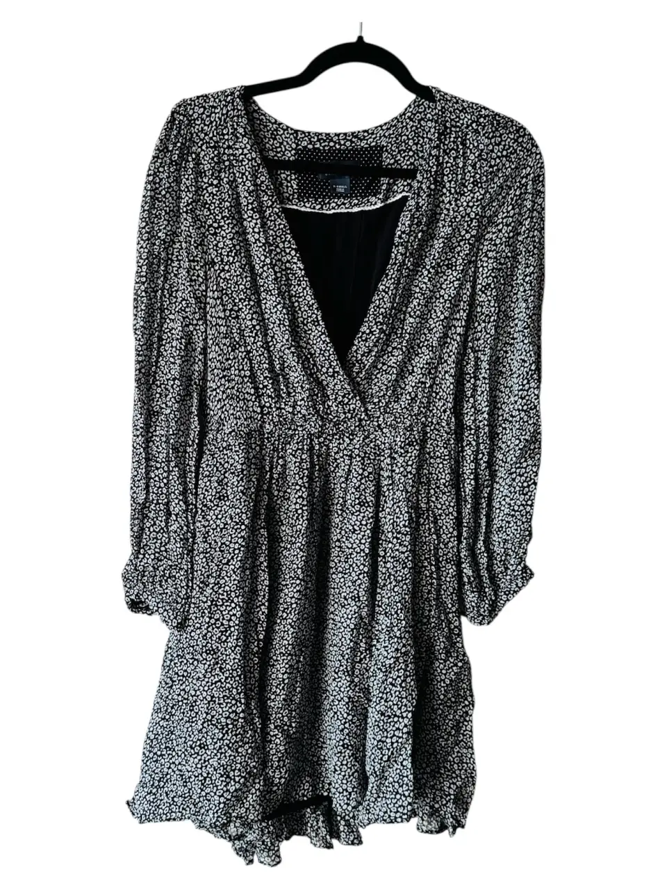Vestido mini con estampado de leopardo en blanco y negro. Corte en la cintura y mangas largas. Ideal para un look casual y moderno.
