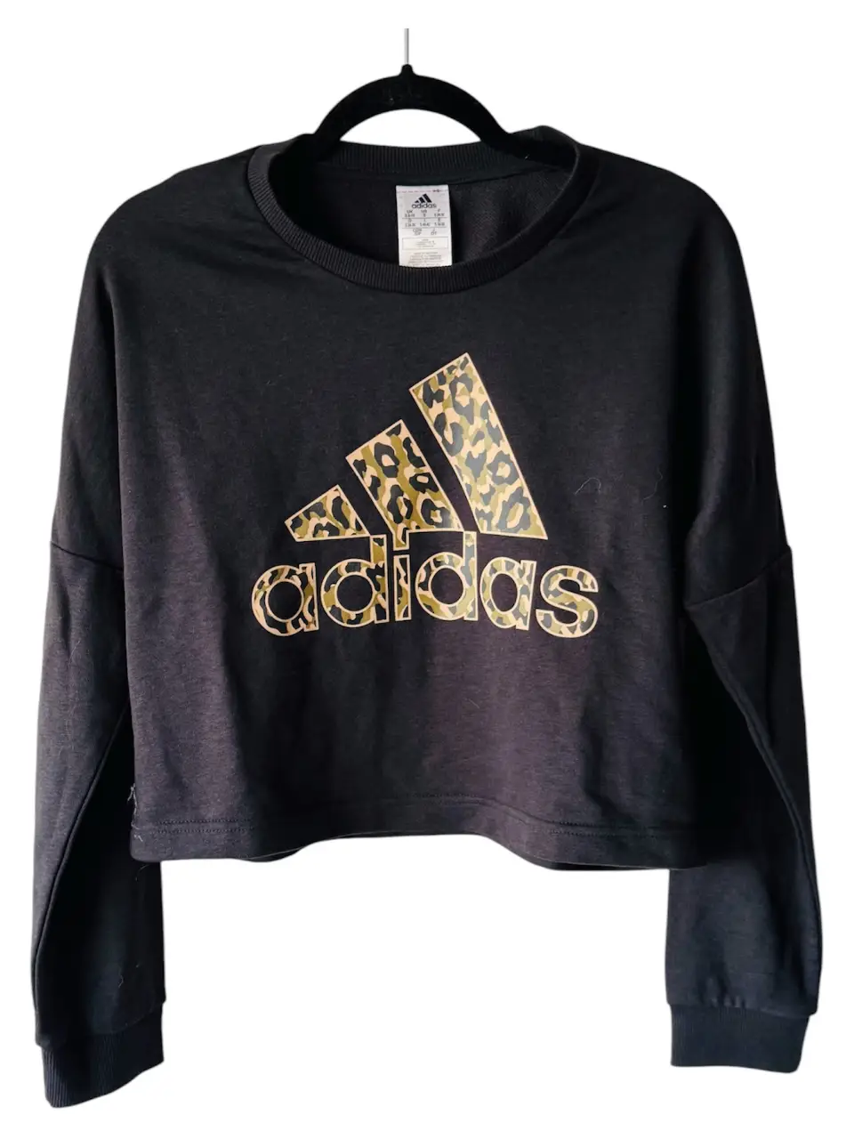 Buzo Adidas negro con logo estampado en animal print camuflado. Talle S. Ideal para un look casual y deportivo.