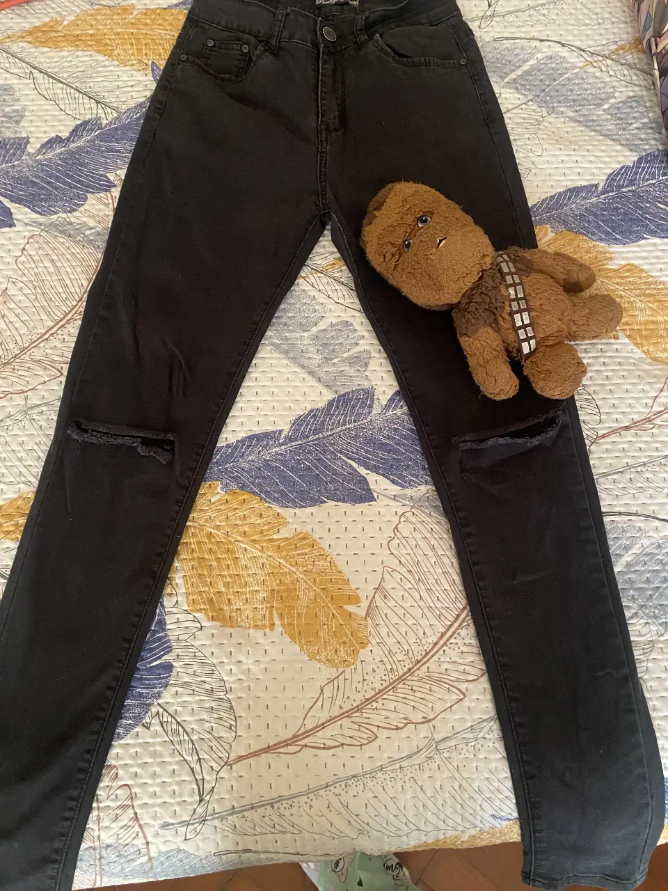 Jeans negros con roturas en las rodillas, tiro alto, bota stretch, ceñido al cuerpo, ideales para un look casual y moderno. Perfecto para combinar con cualquier outfit.