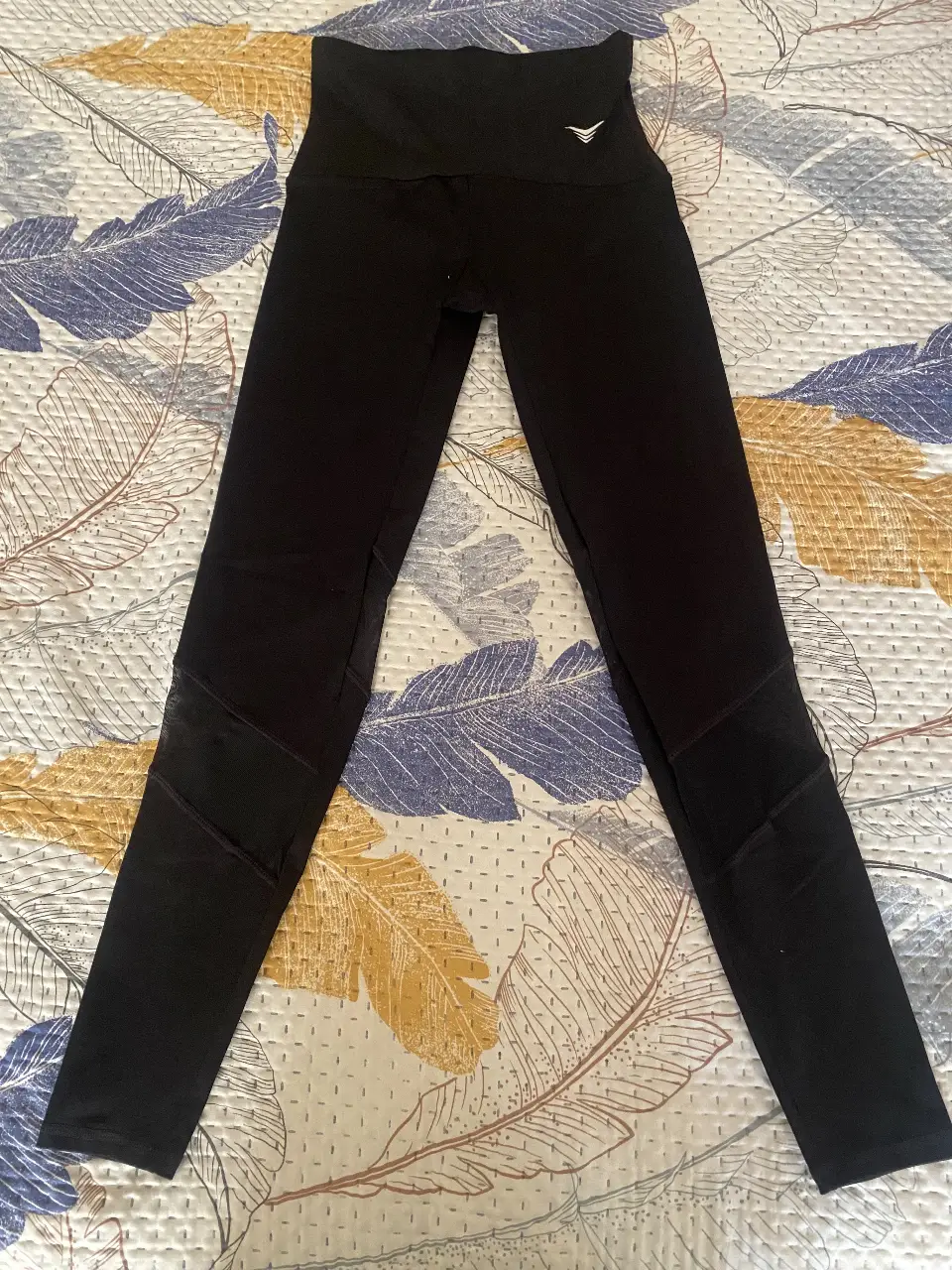 Calzas deportivas negras con detalles de mesh en los laterales. Ideales para entrenar o para un look casual y cómodo.