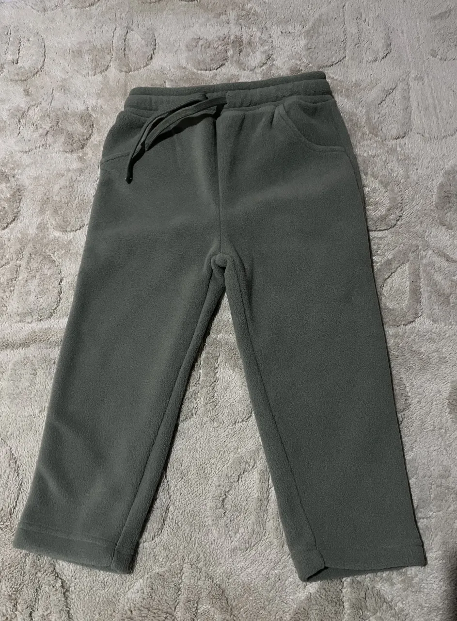 Pantalón de polar gris, ideal para estar cómodo en casa o para actividades al aire libre. Con cintura elastizada y cordón ajustable, bolsillos laterales y corte recto.