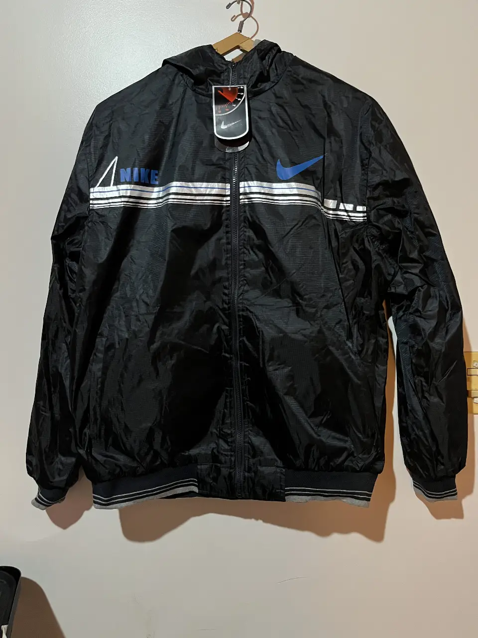 Campera deportiva reversible, negra con detalles blancos y logo en azul. Con capucha y cierre. Ideal para usar en actividades deportivas o para un look casual.no es original