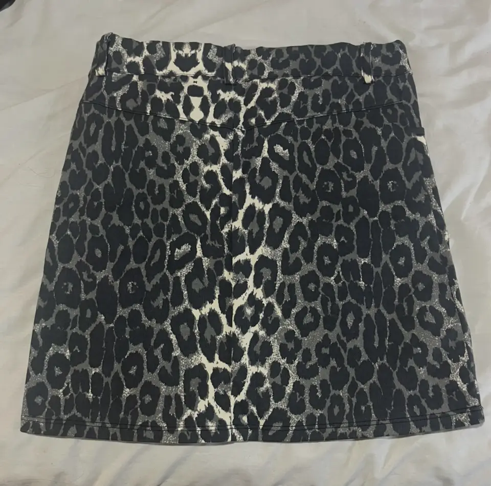 Pollera corta FOREVER21 con estampado de leopardo en blanco y negro. Ideal para un look moderno y audaz. Confeccionada en tela suave y cómoda, perfecta para cualquier ocasión.