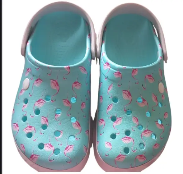 Zuecos Crocs con estampado de flamencos en color celeste y suela rosa. Ideales para un look casual y cómodo.