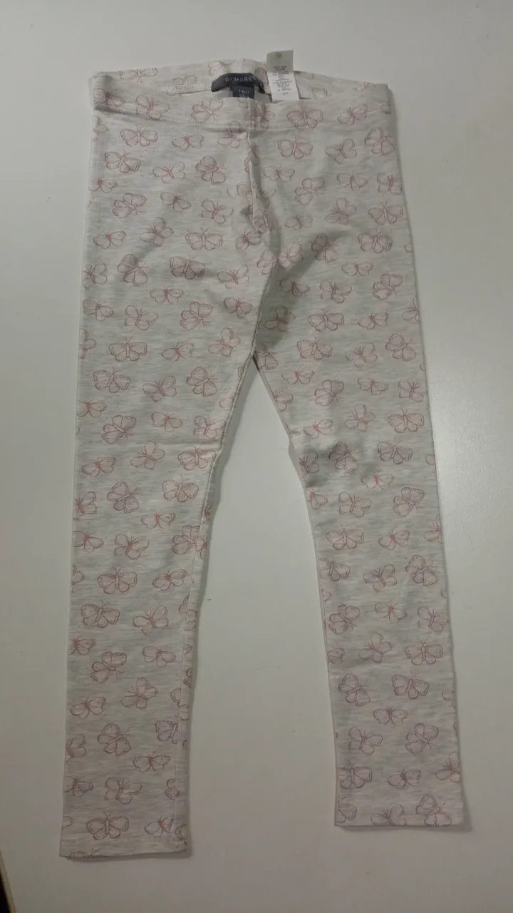 Calzas de niña con estampado de mariposas en color rosa sobre fondo gris. Perfectas para un look cómodo y divertido.