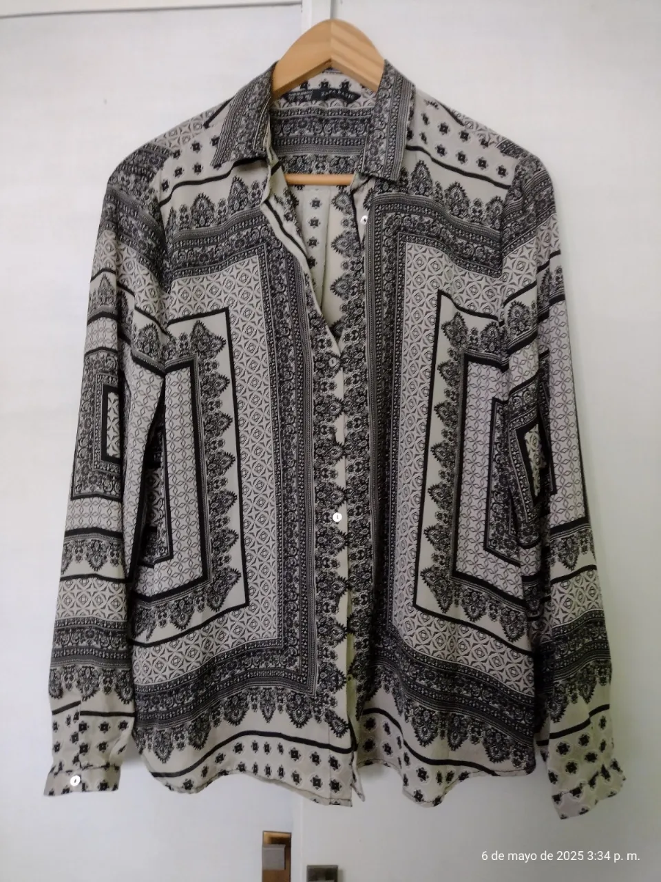 Camisa estampada de mujer, con diseño geométrico en blanco y negro. Manga larga y corte clásico. Ideal para un look elegante y versátil.