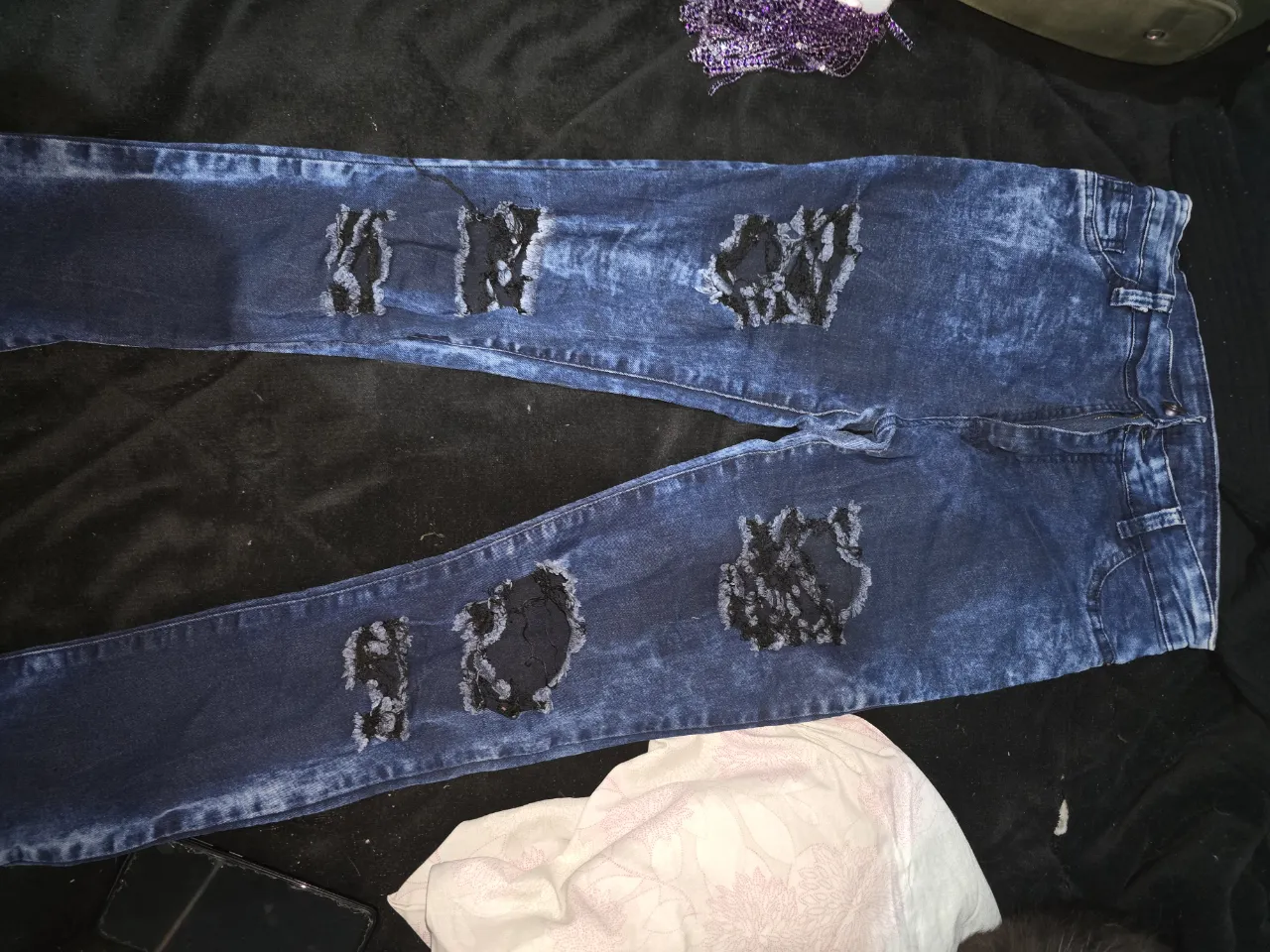 Jeans de tiro alto con roturas y detalles en encaje negro. Lavado tipo 'stone washed' que le da un toque moderno y canchero. Ideales para un look urbano y descontracturado.