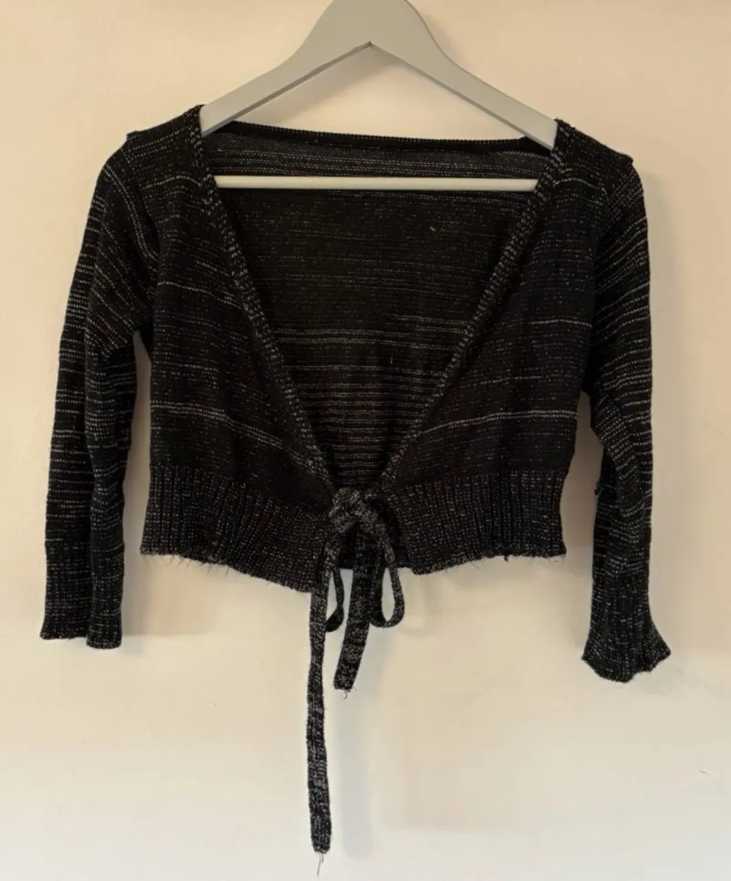 saco corto tipo cardigan en color negro con detalles plateados. tiene un lazo delantero para atar.

medidas tomadas en plano en la última imagen