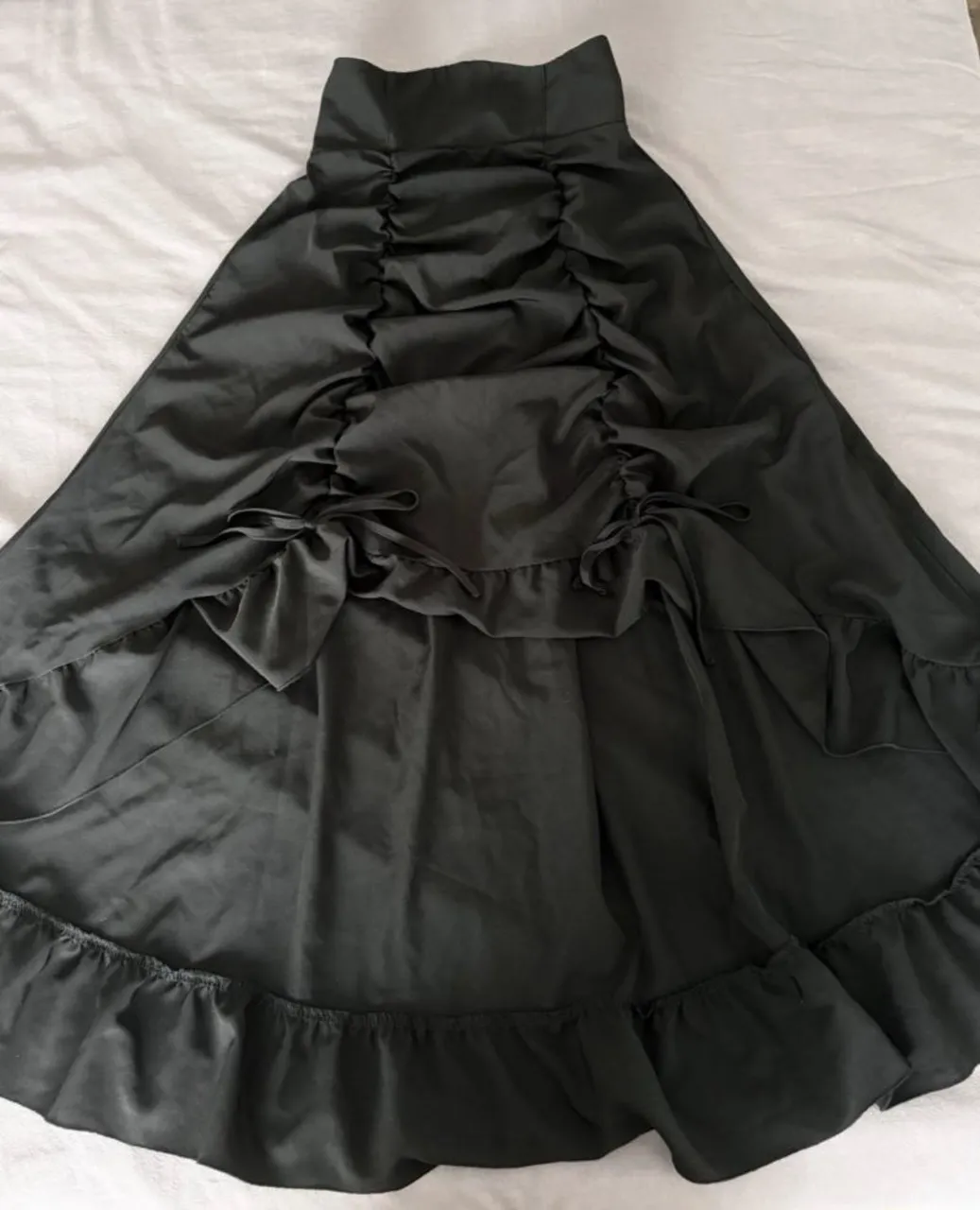 pollera negra tiro alto, frunces en el frente y un bajo con volados asimétricos, más corta adelante y más larga atrás. 
le corté la etiqueta pero nunca fue usada. 
la tela es fresquita y la cintura elastica. 
estilo gótico/alternativo

medidas:
cintura: 65 a 98cm
caderas: 146cm
largo: 87cm