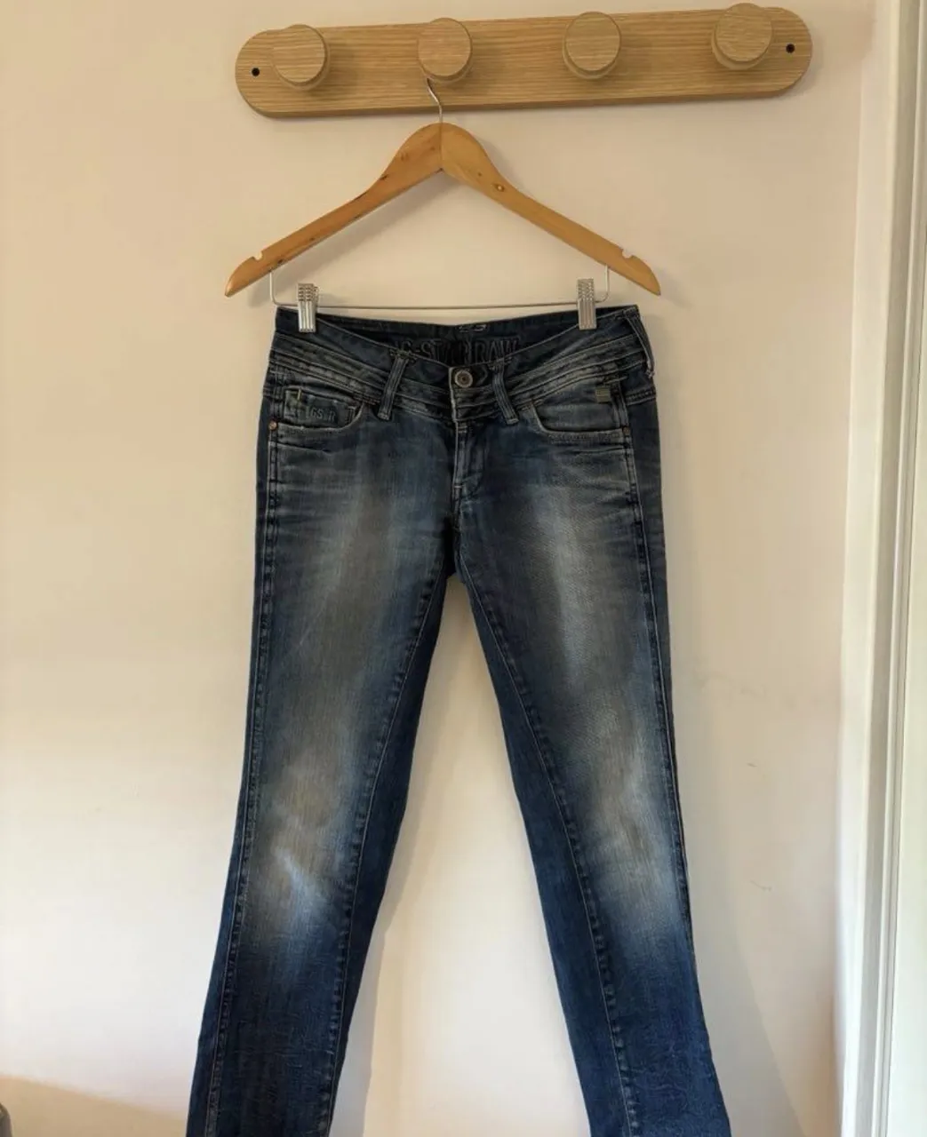Jeans de corte recto, con desgaste y detalles de costura. Poseen bolsillos delanteros y traseros. La marca G-Star Raw es visible en varias etiquetas y detalles.  y2k super tiro bajo
medidas en la última foto