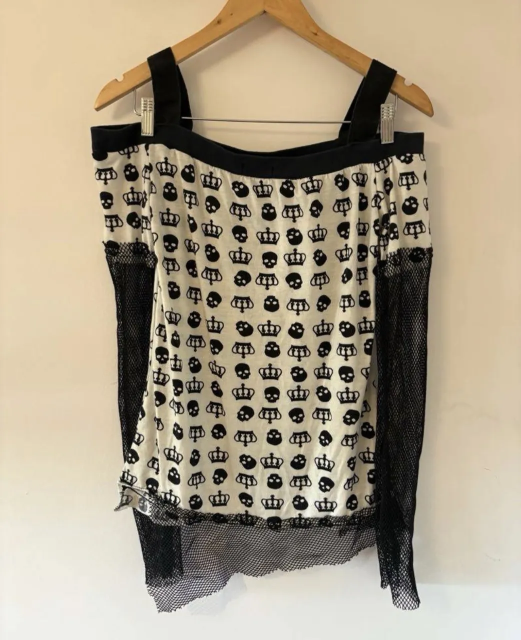 remera youkai kei talle s, blanca con estampado de calaveras y coronas negras. tiene hombros descubiertos y mangas largas de red. 
medidas en plano en la última imagen