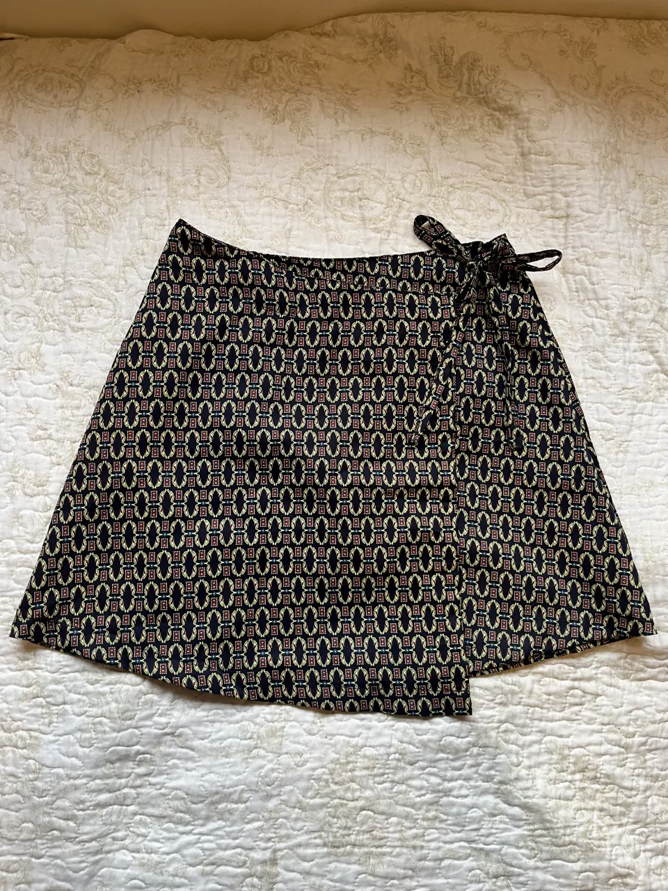 Pollera corta estampada con lazo para atar a un costado. Posee un botón negro en la parte superior.

Nuevo sin usar