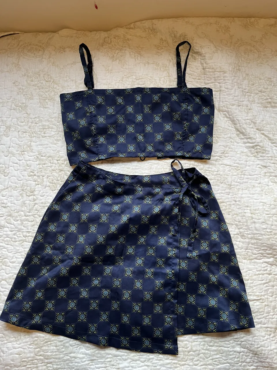 Conjunto de dos piezas: top corto con tiras y falda cruzada con lazo. 

Nuevo sin usar. 