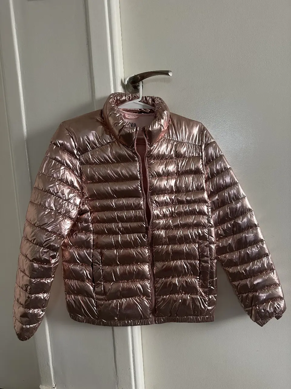 Campera de pluma metalizada color rosa para niña o adulto, de la marca Zara Kids. Ideal para el invierno, con cierre y cuello alto.