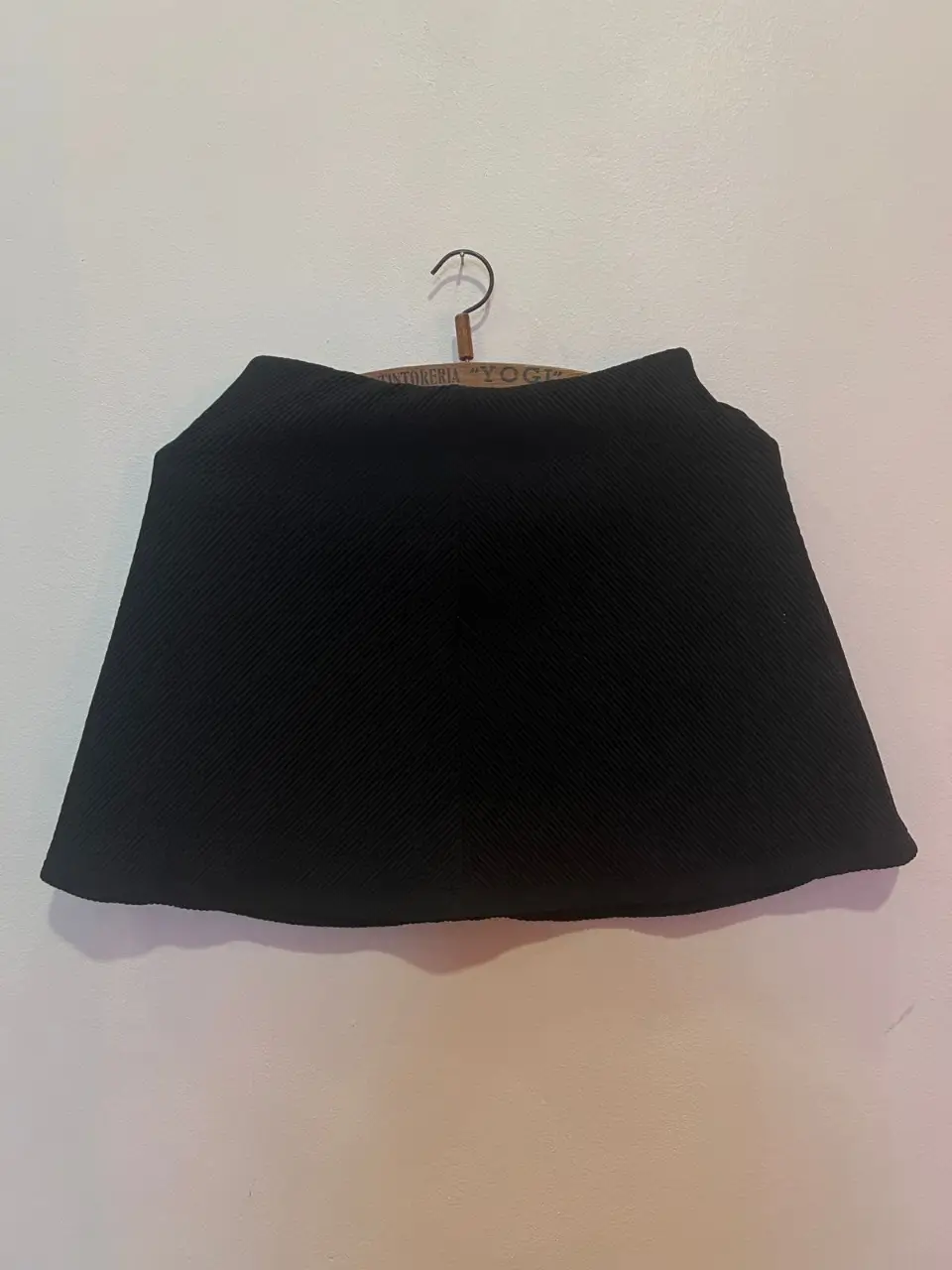 Pollera negra de corte recto, con un diseño plisado que le da un toque elegante y sofisticado. Ideal para crear looks formales o semi-formales. TALLE:SMALL/Largo:39m// cintura :31cm