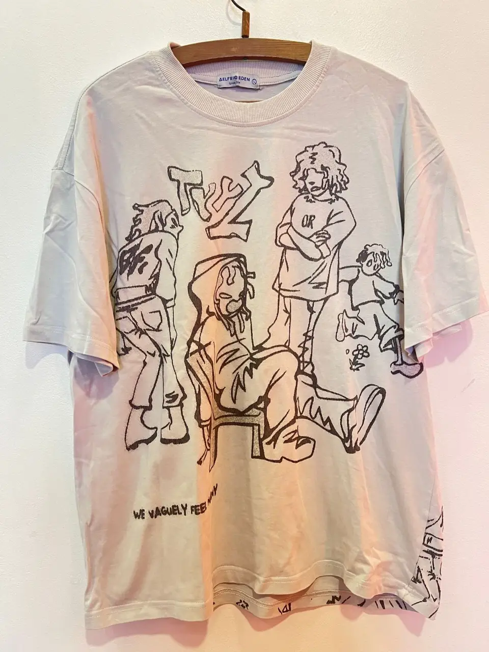 Remera de hombre de color gris claro con estampado de diseño artístico en negro. Estilo streetwear, ideal para un look casual y moderno. Talle : large// largo: 71cm // ancho: 57 cm //mangas :22 cm