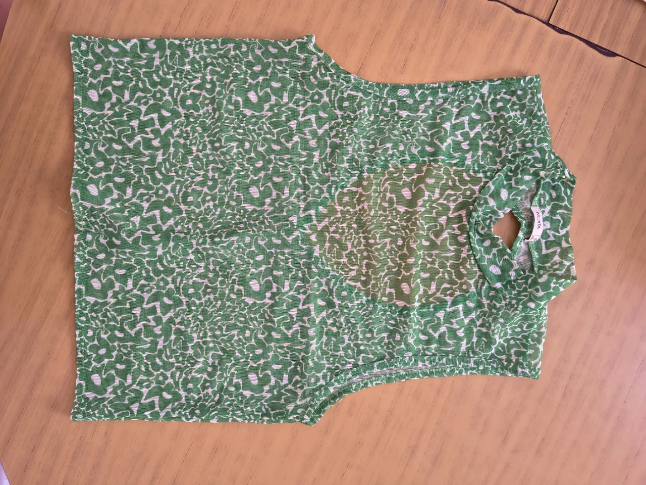 Top transparente, escotado en la spalda y cuello alto. Posee un estampado abstracto en verde y blanco, ideal para un look canchero y moderno. Perfecto para salidas informales.