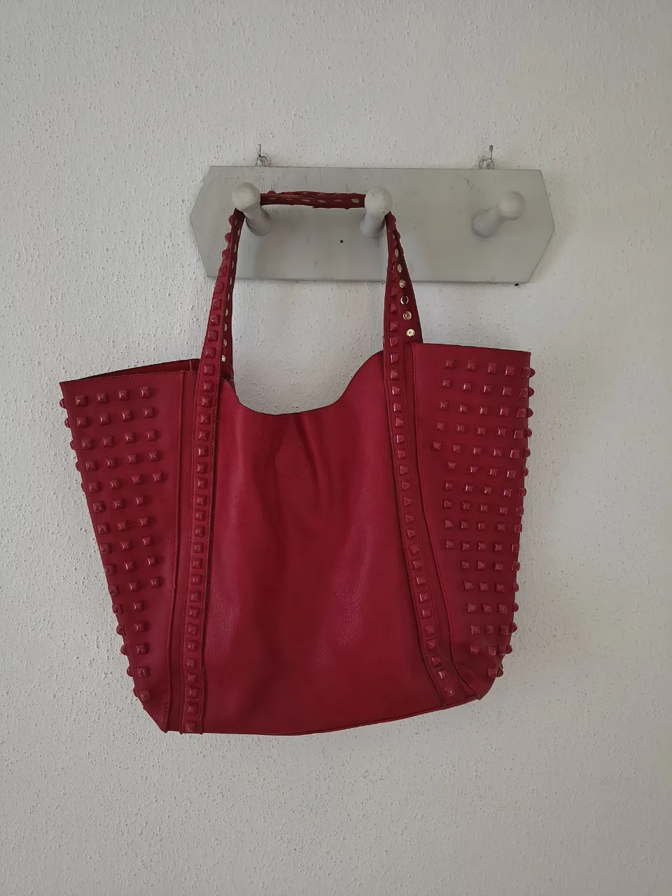 Bolso tote rojo súper canchero, con tachas que le dan un toque rockero y moderno. Ideal para llevar todo lo que necesitás con mucho estilo. Perfecto para el día a día o una salida informal.