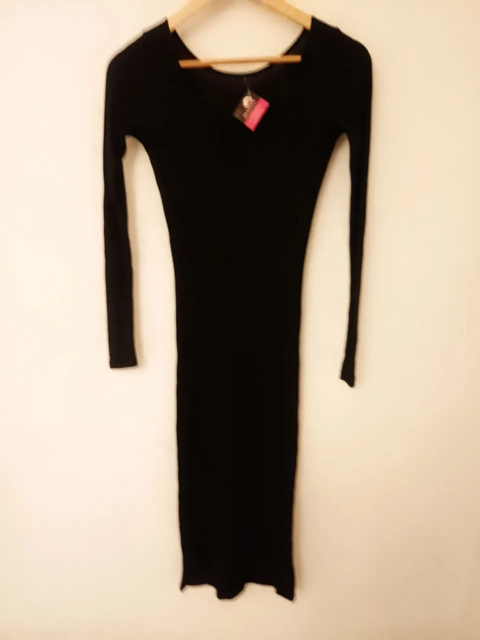 Vestido negro de manga larga con escote en V.