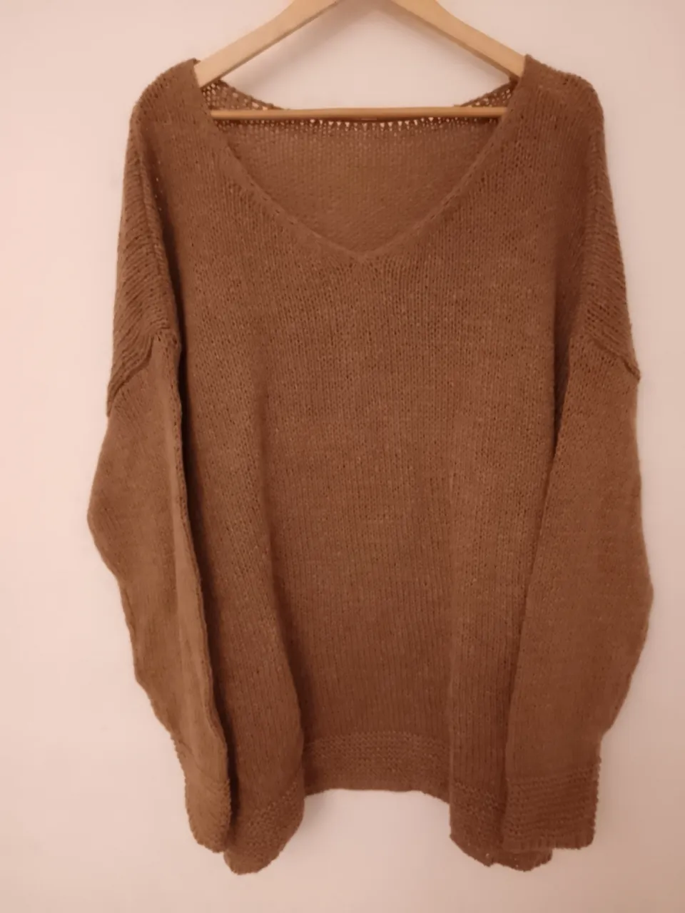 Sweater de lana tejido con cuello en V y mangas largas. Posee puños y cintura tejidos. es moda oversize