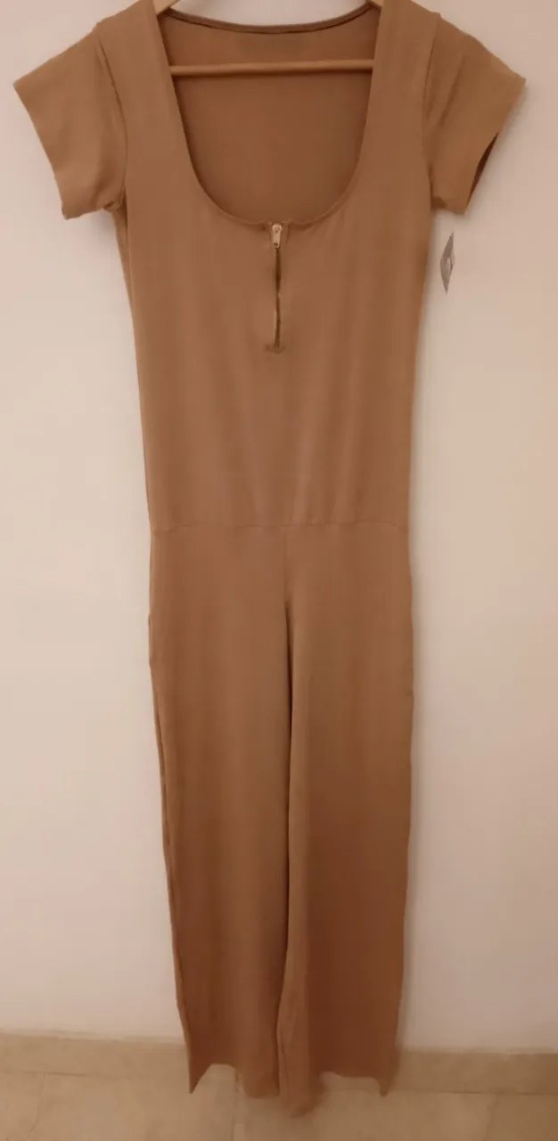 Mono largo de color marrón claro, con mangas cortas y escote redondo con cierre metálico al frente. La cintura está marcada y la parte inferior es de pantalón largo.Tela spandex, va para talle S y M