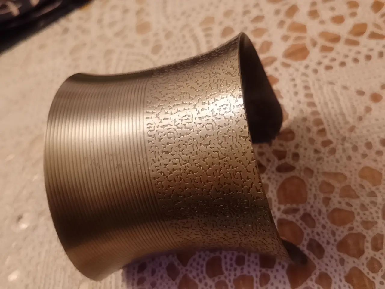 Pulsera ancha de metal dorado con diseño texturizado y detalles lineales. Ideal para un look moderno y sofisticado.