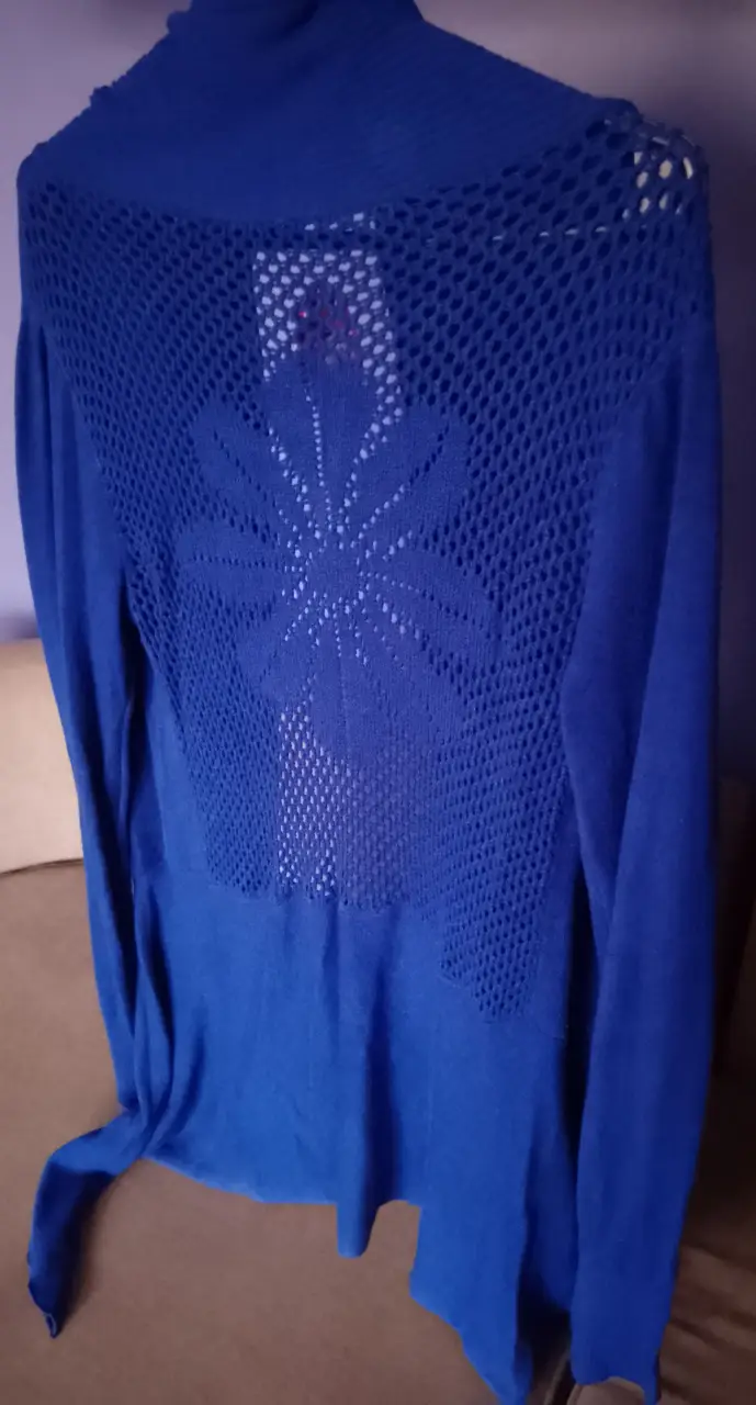 Cardigan azul con espalda calada y diseño floral. Ideal para un look elegante y cómodo.
