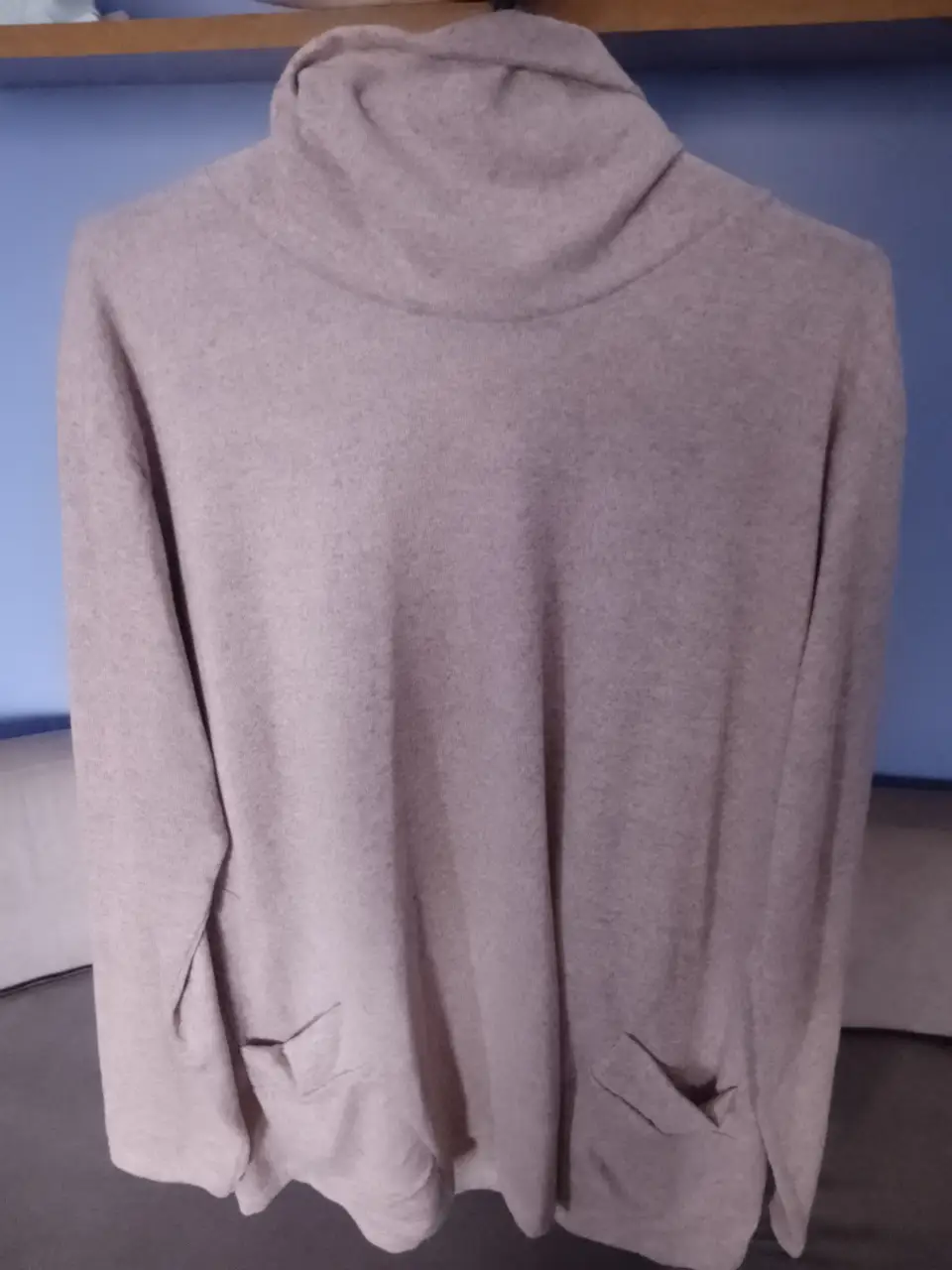 Sweater largo de mujer con cuello alto y bolsillos. Ideal para un look casual y cómodo.