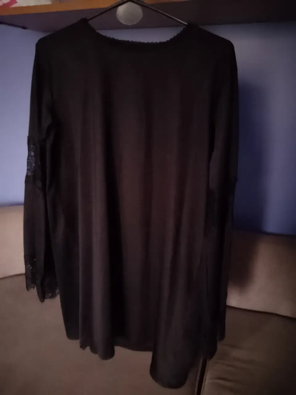 Vestido/camisola  negro con mangas largas y detalles de encaje en los puños. Ideal para eventos formales o salidas nocturnas.