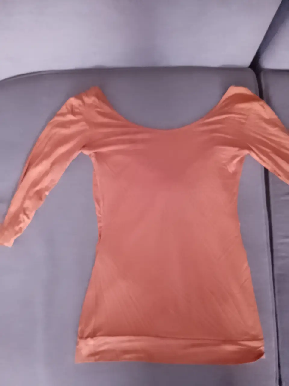 Remera naranja con escote en la espalda y detalle de moño runcido en el frente o detrás. deal para un look elegante y moderno.