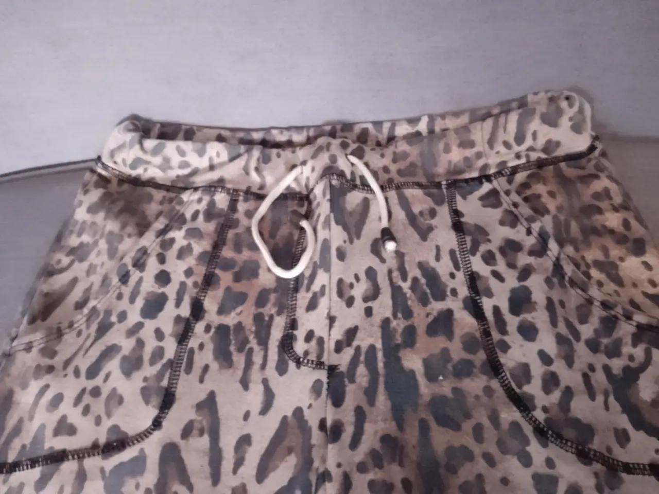 Pantalón de jogging con estampado de leopardo. Tiro medio, con cintura elastizada y cordón. Bolsillos laterales. Ideal para un look casual y cómodo.