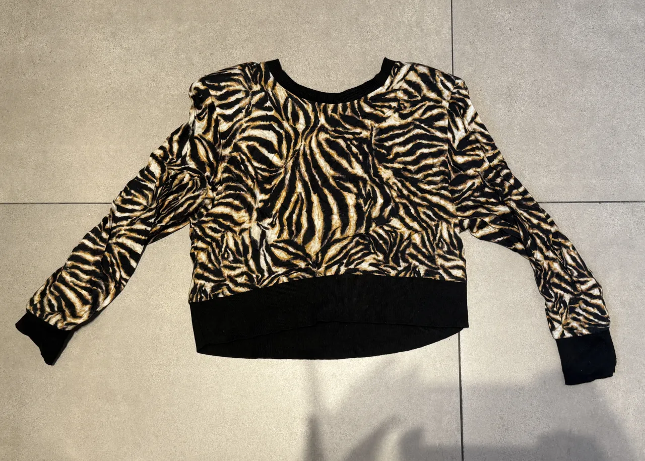 Buzo crop con estampa de cebra y puños y cintura de ribb negro.