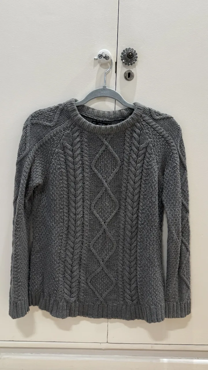 Sweater de punto gris con diseño de rombos en la espalda y mangas. Cuello redondo y tejido grueso, ideal para el invierno. Marca Zara Knit.