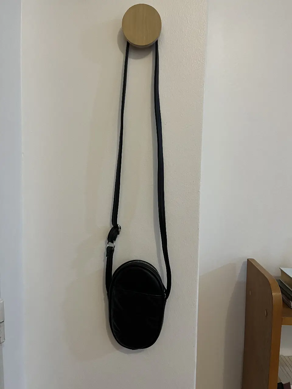 Bandolera negra con diseño acolchado. Con bolsillo delantero 