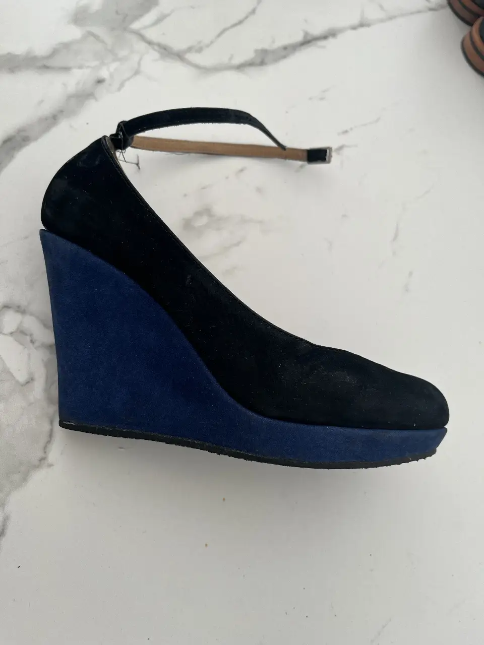 Elegantes zapatos de taco alto con diseño de cuña en gamuza negra y detalles en azul. Ideales para eventos formales o salidas nocturnas.