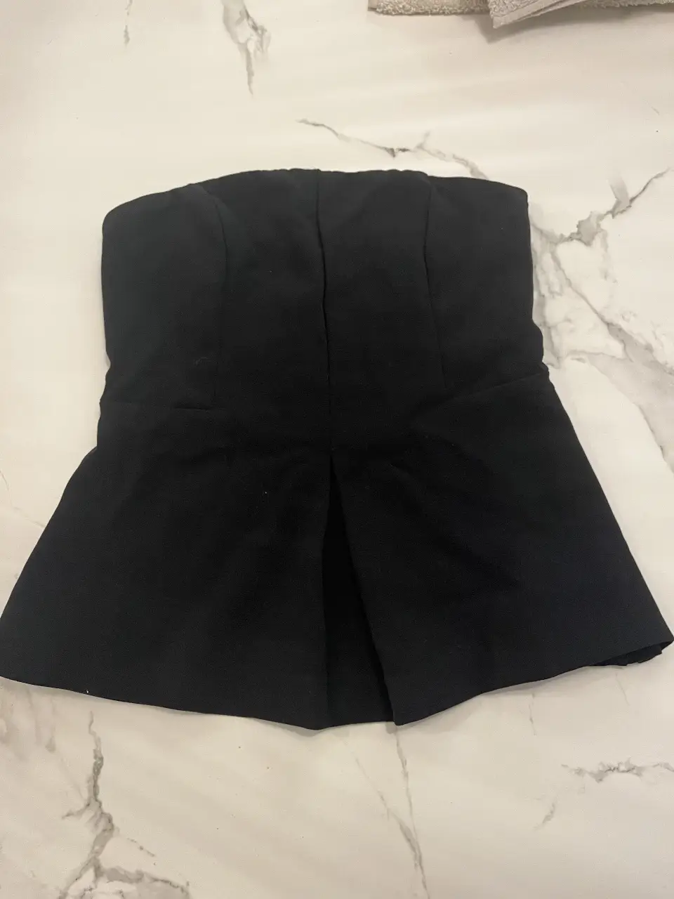 Top negro strapless con detalle de pliegues en la parte delantera. Ideal para eventos formales o salidas nocturnas.