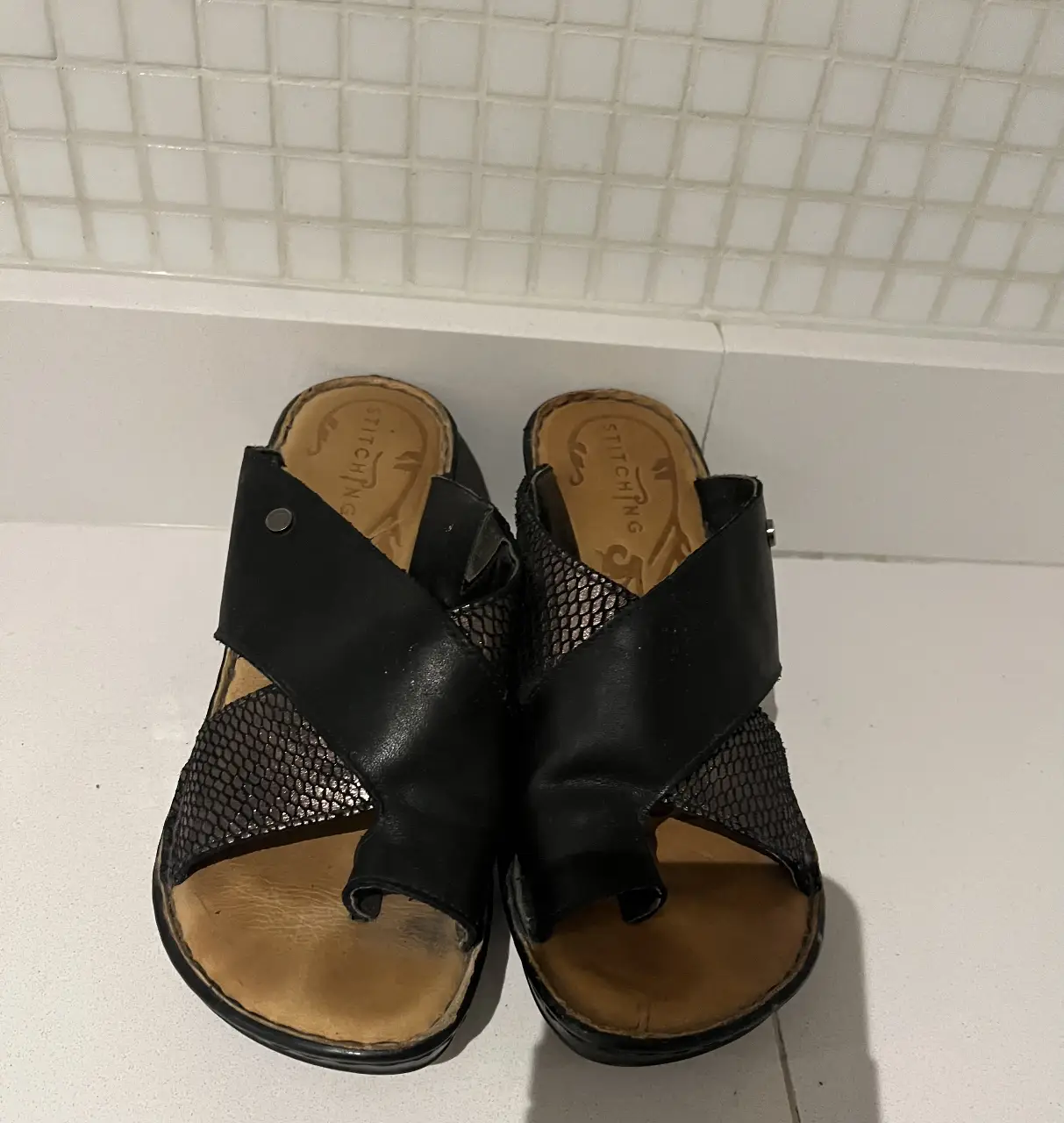 Sandalias Stitching negras con detalles en cuero y diseño cruzado. Ideales para un look casual y cómodo.