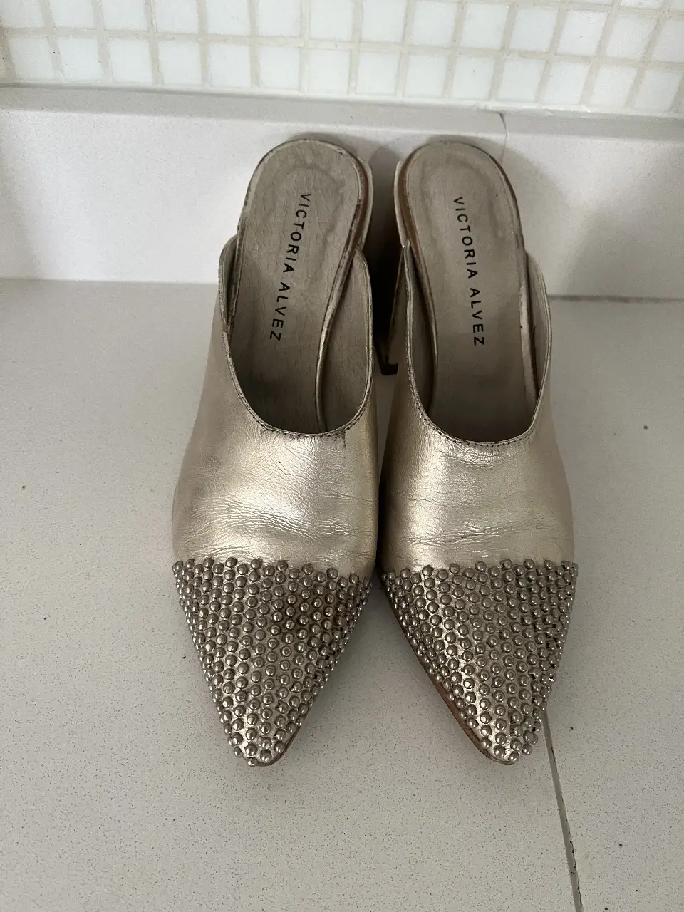 Elegantes tacos dorados con detalles de strass en la punta. Ideales para darle un toque sofisticado a cualquier look de fiesta.