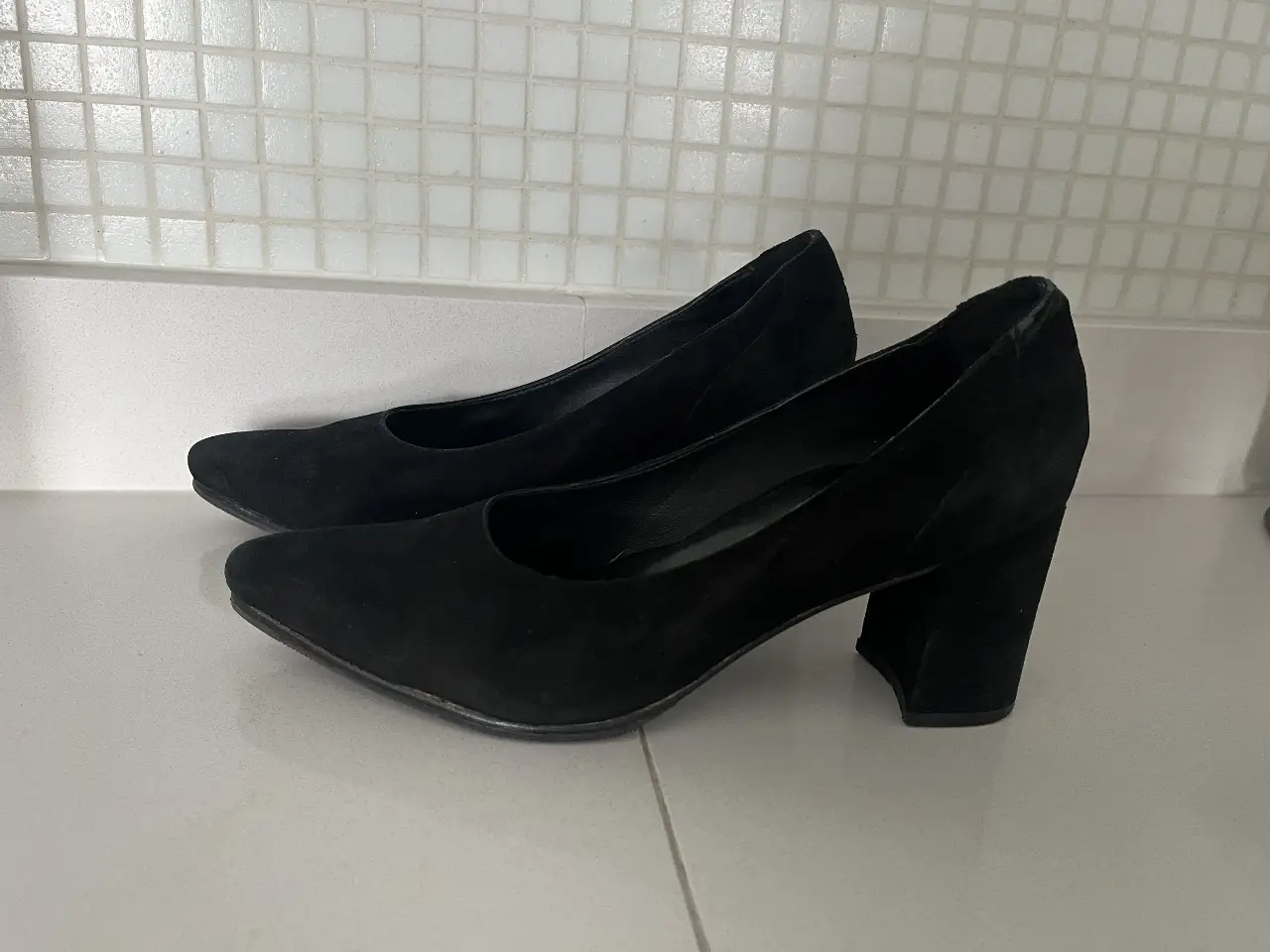 Elegantes zapatos de taco alto negros, ideales para eventos formales y salidas nocturnas. Confeccionados en gamuza, ofrecen un estilo sofisticado y atemporal.