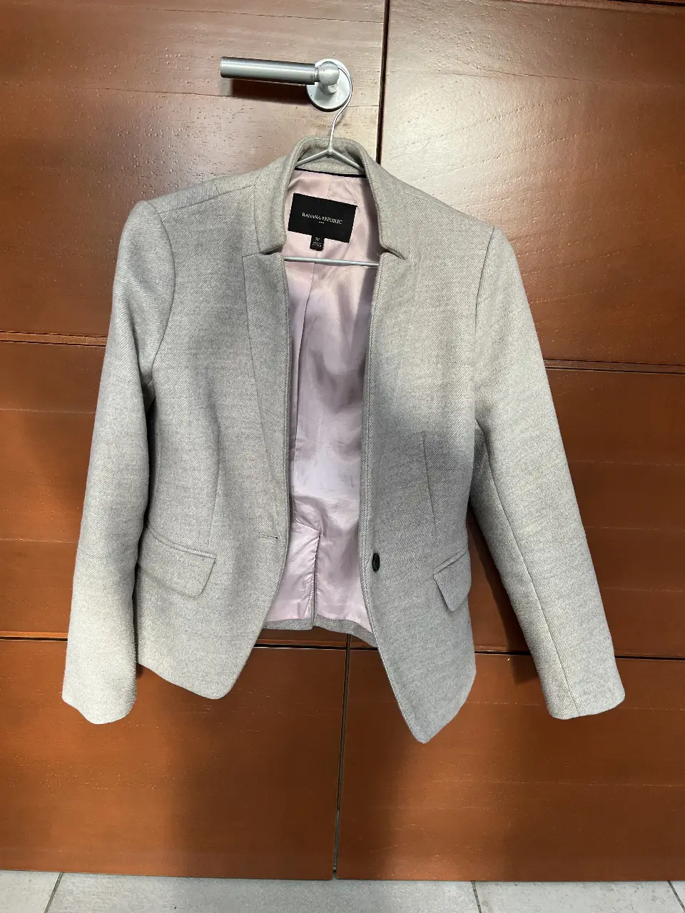 Blazer gris de mujer, de la marca Banana Republic. Ideal para un look formal o de trabajo. Confeccionado en un tejido de calidad, este blazer ofrece un ajuste elegante y sofisticado. Perfecto para combinar con pantalones de vestir o faldas.