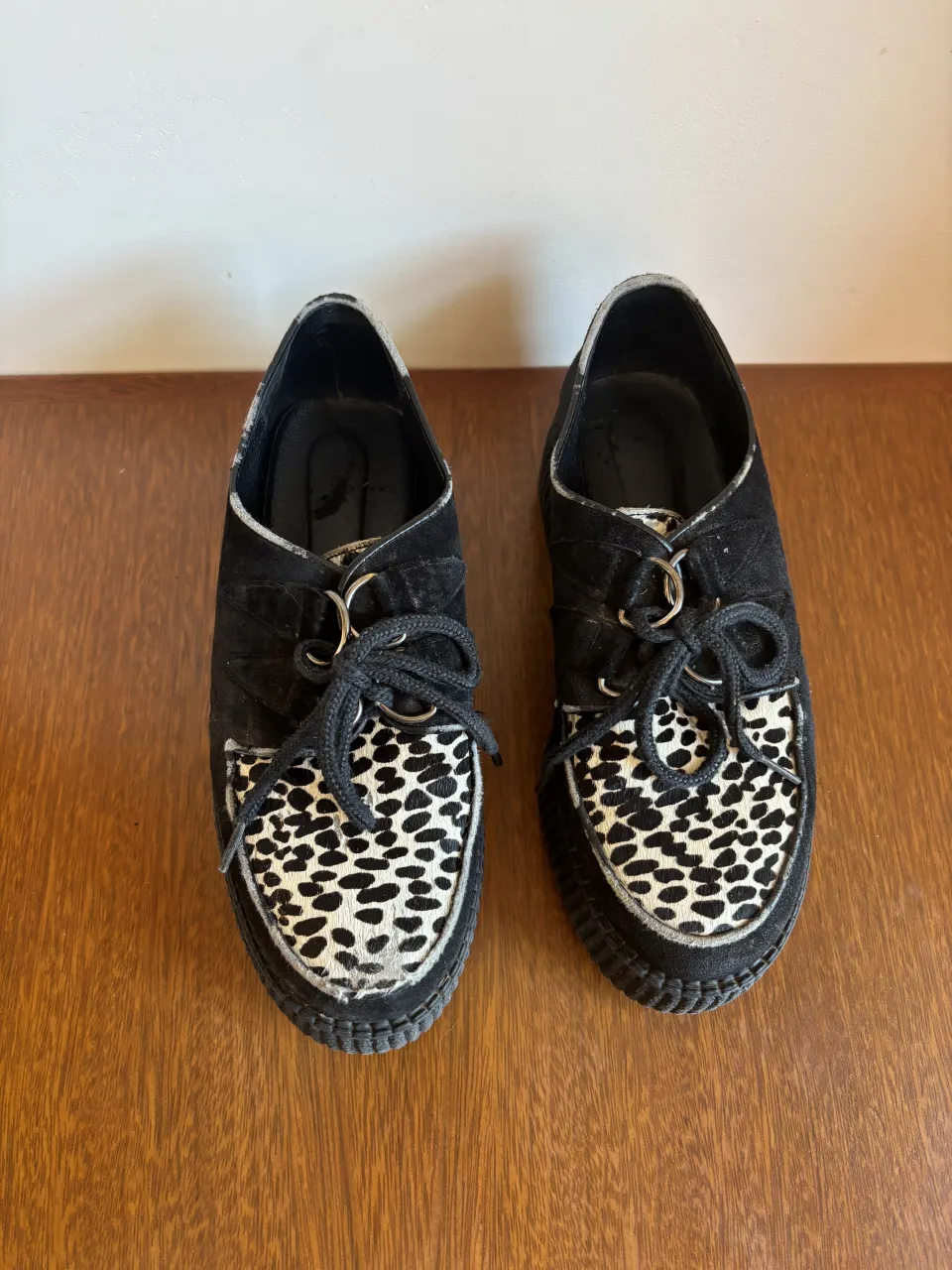 Zapatos gamuzones negros con cordones y detalle de animal print en la punta. 