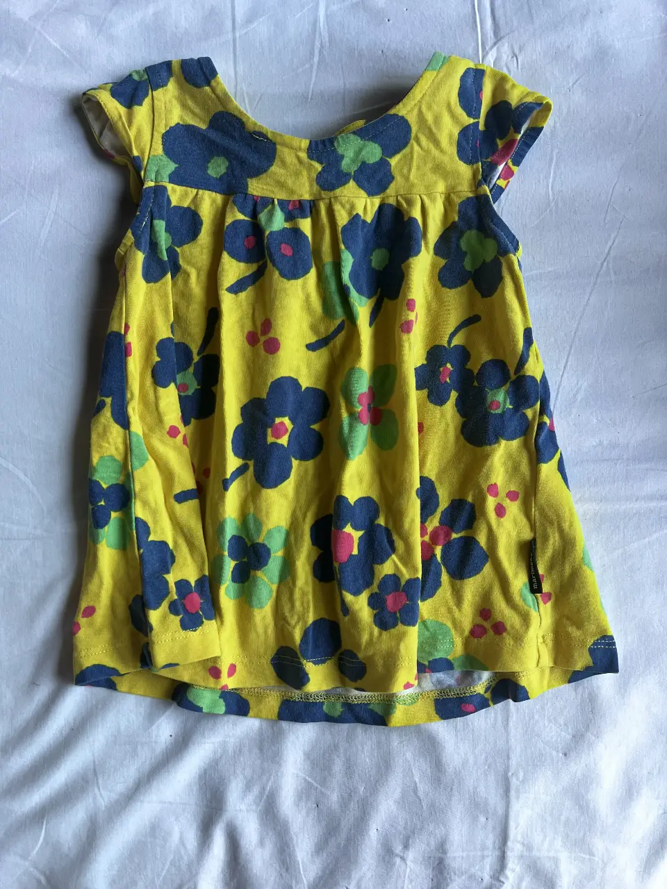 Vestido de niña Marimekko, amarillo con estampado floral azul y detalles en rosa y verde. Talle 80/12M, ideal para el verano.