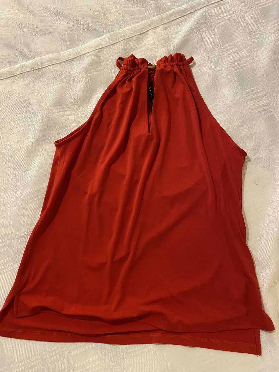Musculosa roja con cuello halter y detalle de fruncido. Ideal para un look canchero y fresco.